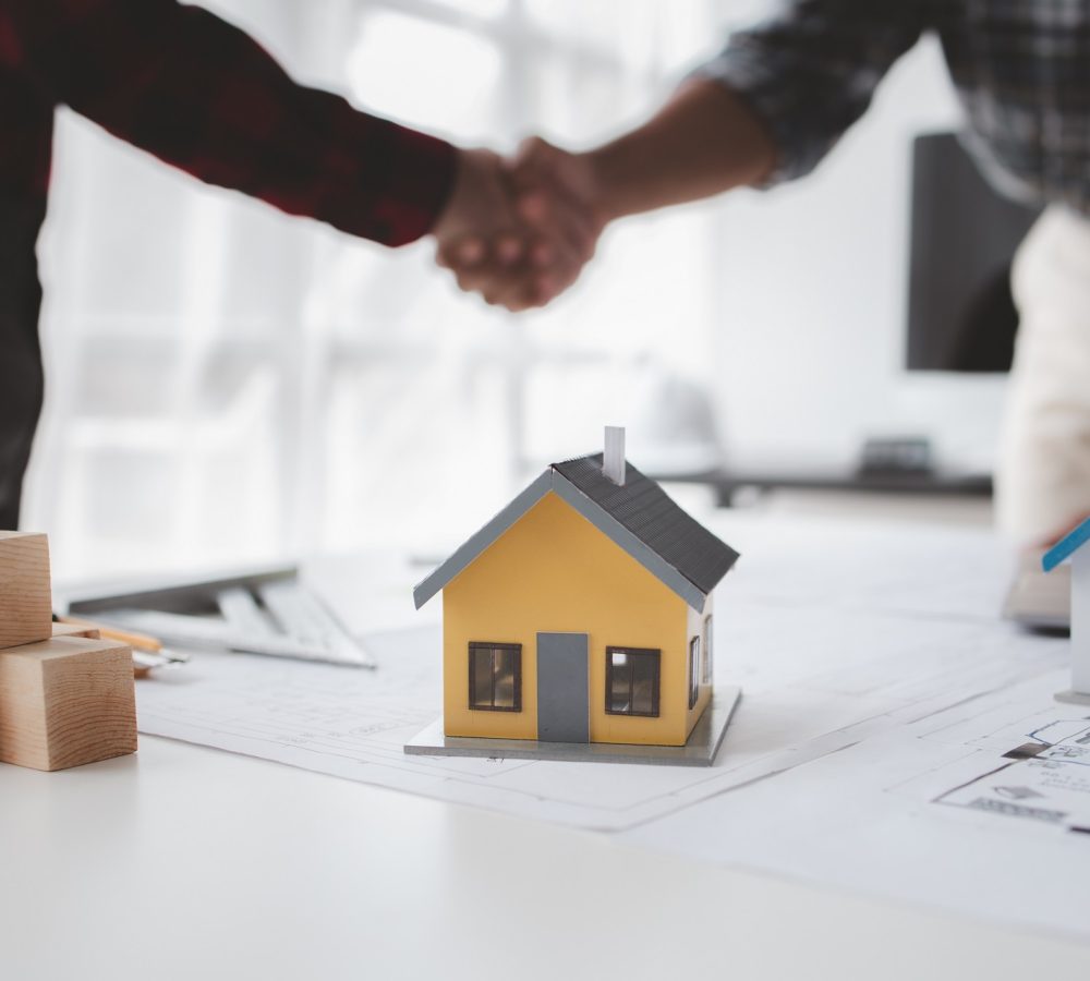 The home design architects are reviewing the house plan draft, t The home design architects are reviewing the house plan draft, the project commissioned by the client, and the custom design before delivery. Interior design and decoration ideas.